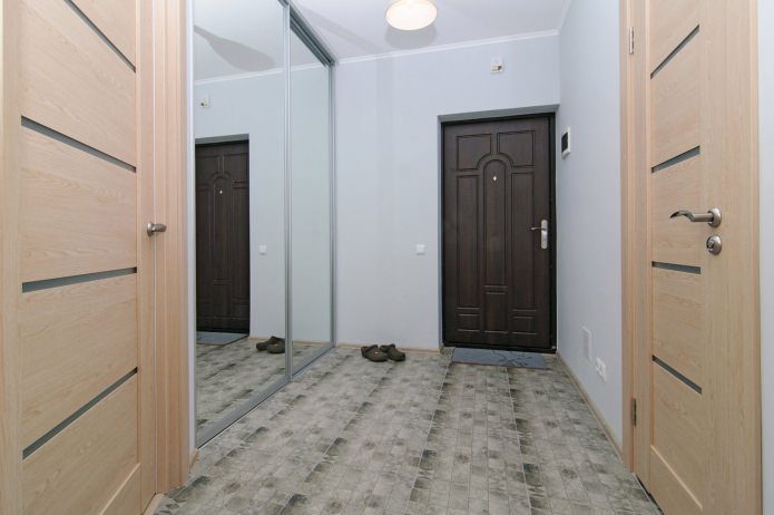 hall de entrada com um guarda-roupa espelhado no design de um apartamento de um quarto