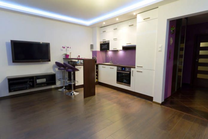 Progettazione di una cucina-soggiorno con bancone bar nei toni bianco e viola