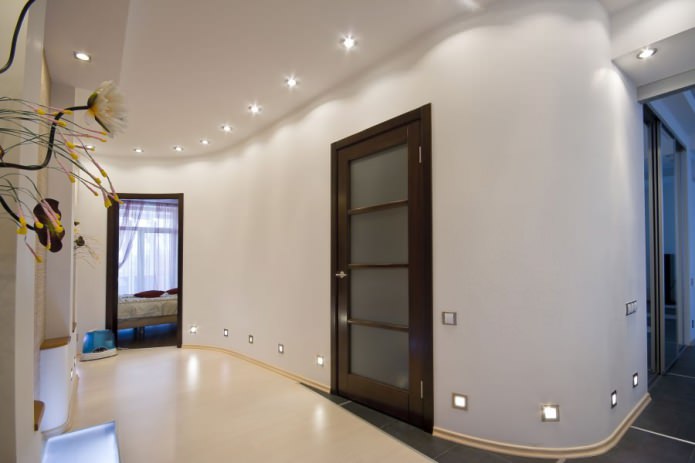 en kombination av ljusa väggar med en mörkbrun dörr med glasinsatser