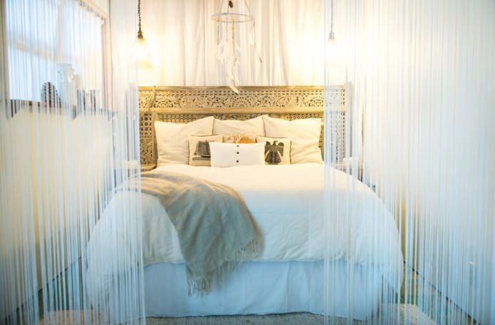 Camera da letto con tende bianche avvolgenti