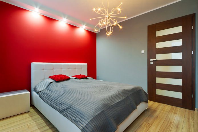minimalistinis kambarys su raudona akcento siena