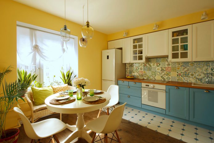 virtuve ar dzeltenām sienām un zilu un baltu komplektu