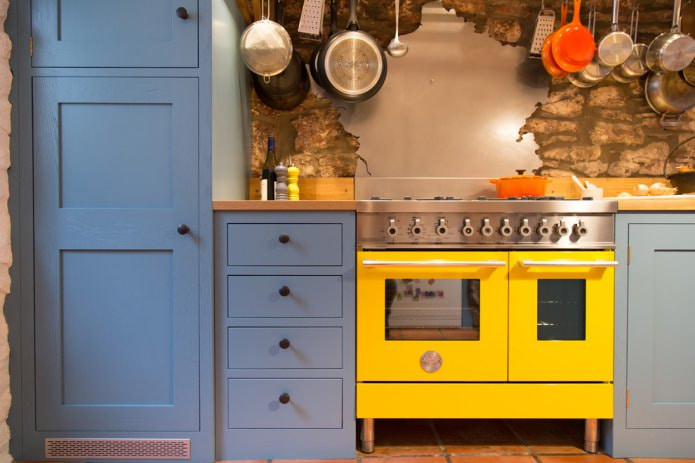 geltonas krosnies fasadas mėlynoje virtuvėje