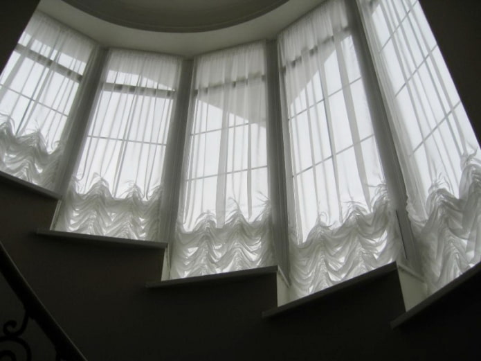 Österrikiska gardiner på fönstren längs trappan