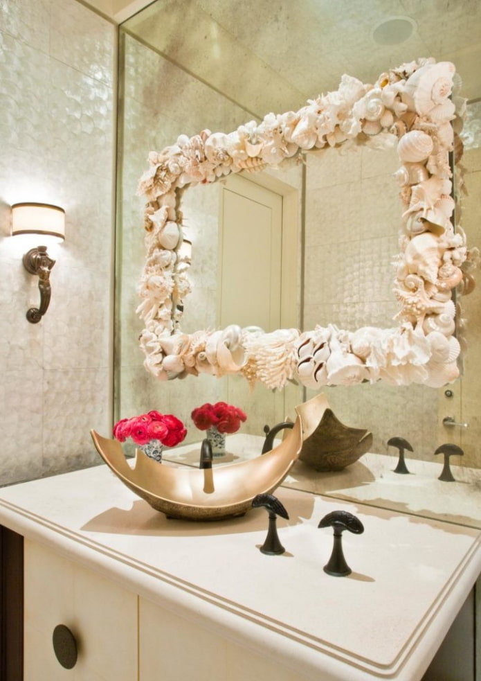 spogulis ar čaumalām vannas istabas interjerā