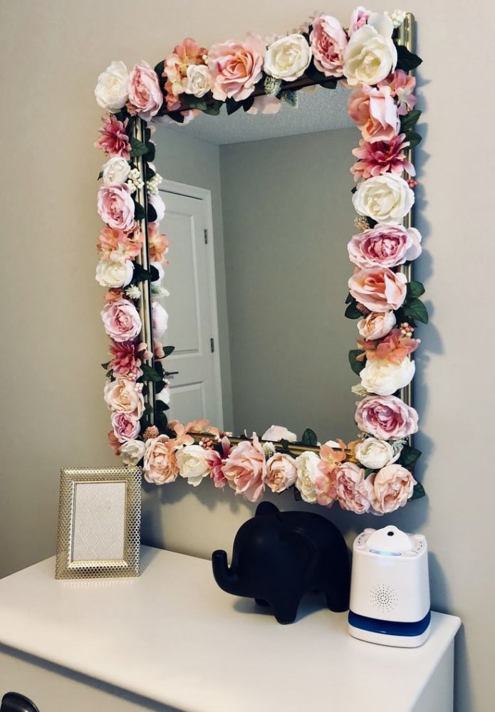 Espejo decorado con flores en el interior.