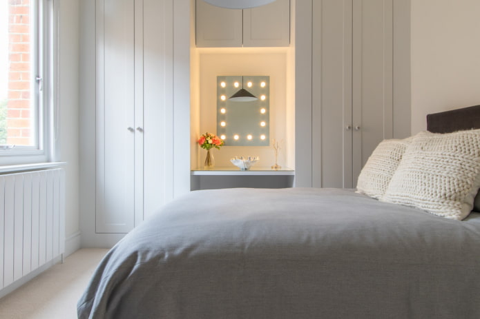 uno specchio con lampadine attorno al perimetro della camera da letto