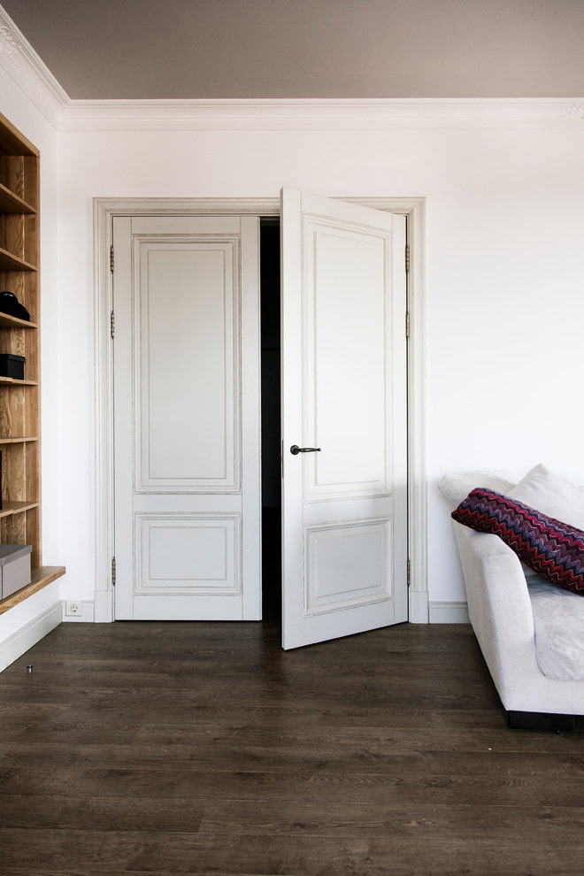 vita dörrar med ett mörkt golv i interiören