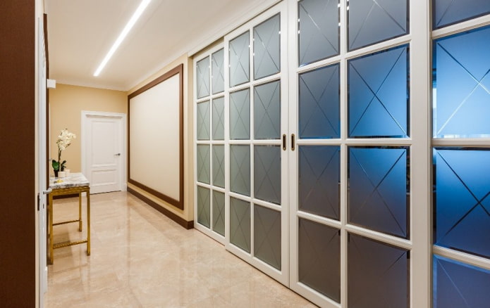 baltas durvis ar stikla ieliktņiem interjerā