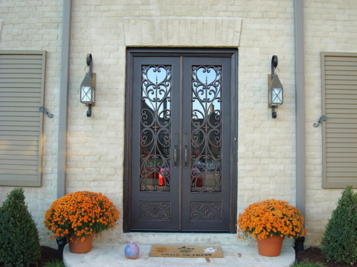 Veranda eines Landhauses mit einer Eingangstür mit Schmiede und Glas