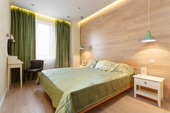 säng med grön sängäcke i sovrummet
