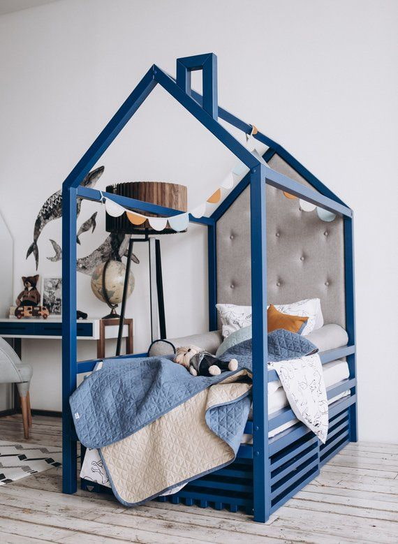modrá postel v podobě domu v dětském pokoji