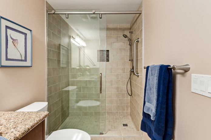 bany amb dutxes de rajola beige a l'interior