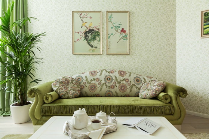 žalia minkšta sofa su gėlėmis interjere