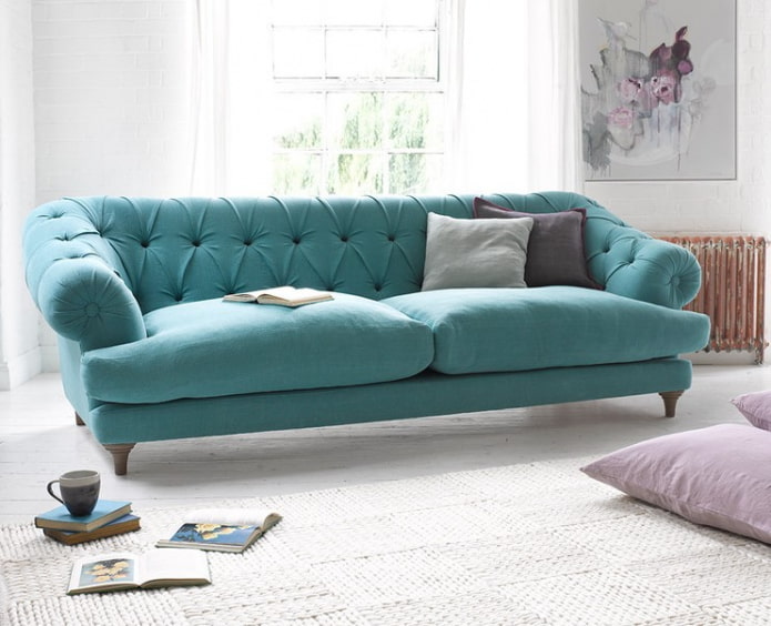 sofa turquoise dengan kaki di kawasan pedalaman