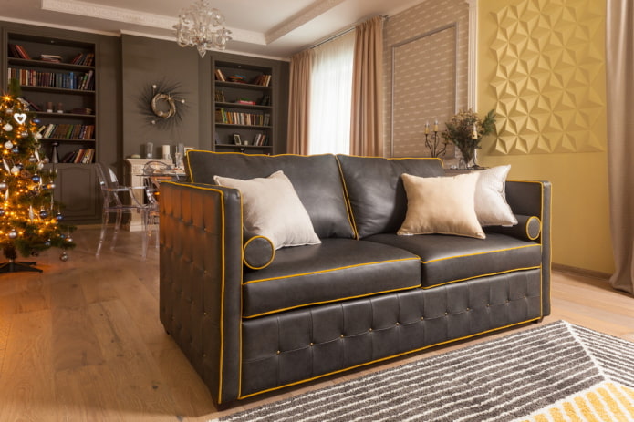 Czarna sofa z pomarańczowymi przeszyciami