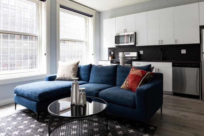 modelo de sofá con una otomana de color azul en un interior