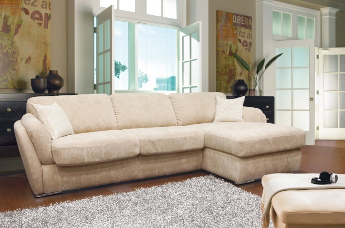 modelo de sofá con otomana beige en el interior