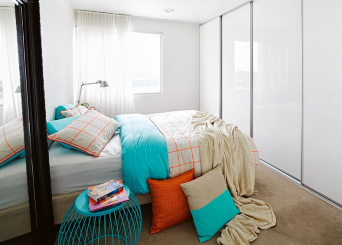 Bett gegenüber Schrank mit glänzenden Türen