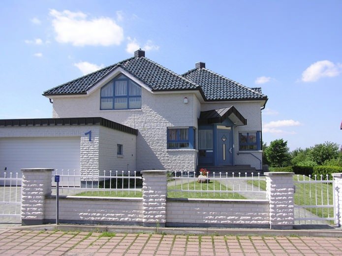 fachada texturizada branca de uma casa de tijolos