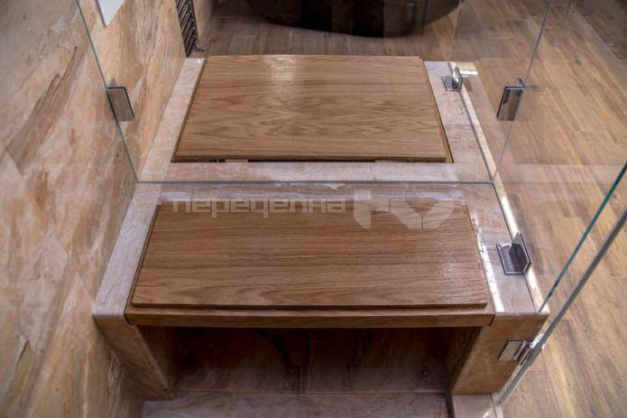 lavice ve sprchové kabině v designu velké koupelny