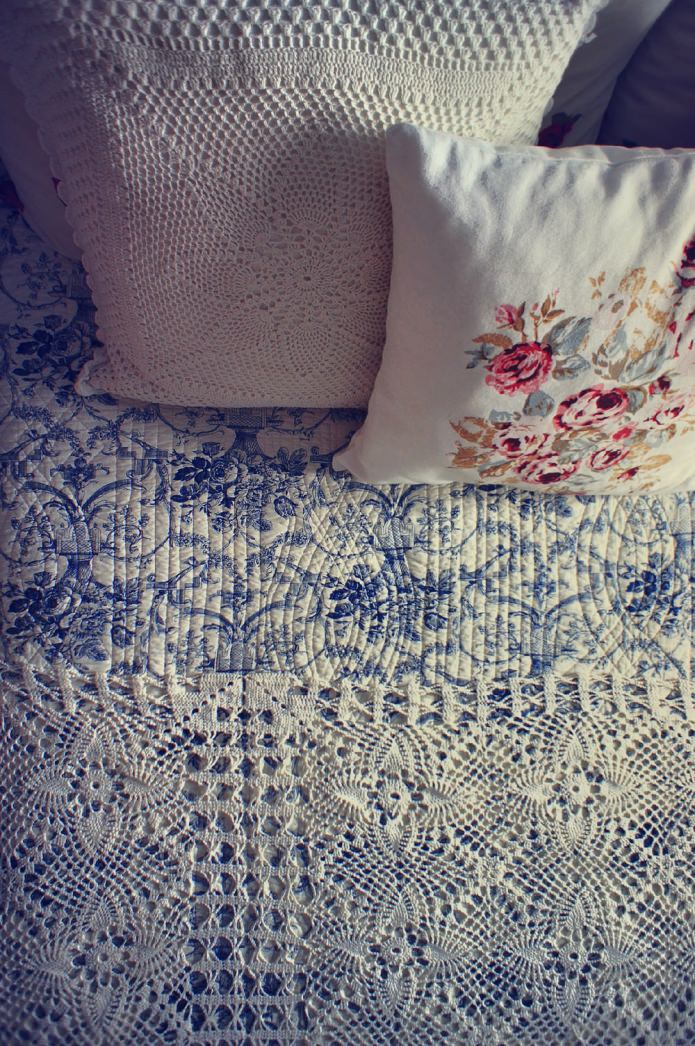 oreillers et couvre-lit en dentelle dans une chambre rustique